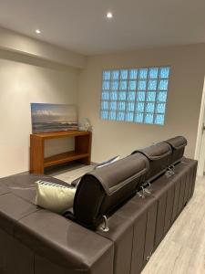 a leather couch in a living room with a window at LA CASA DEL MUELLE in Avilés