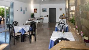 a restaurant with tables and chairs with blue table cloth at Gorgona Hotel in Amoudara Herakliou