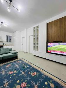 sala de estar con TV de pantalla plana y sofá en Mimo’ s House en Vlorë