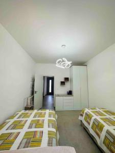 1 dormitorio con 2 camas y lámpara de araña en Mimo’ s House, en Vlorë