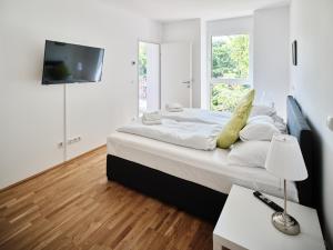 a bedroom with a bed with a tv on the wall at MySchönbrunn Apartments in Vienna