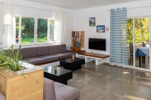 a living room with a couch and a tv at Gorgona Hotel in Amoudara Herakliou
