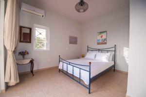 a bedroom with a bed and a window at Villa Pyla in Paralia Demonias