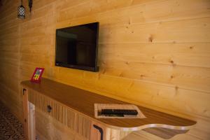 Habitación con pared de madera y TV. en Ekinoks Hotel - Adults Only, en Cıralı