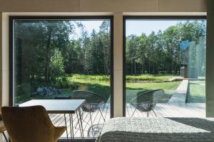 Zimmer mit einem Tisch und Stühlen sowie einem großen Fenster in der Unterkunft Pala Stay in Pala