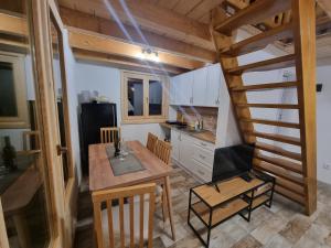 a kitchen with a dining room table and a staircase at Etno Zvuk Tisine Djukic in Valjevo