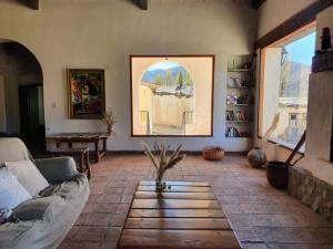 a living room with a couch and a large window at Terra - Casa de Campo in Cachí