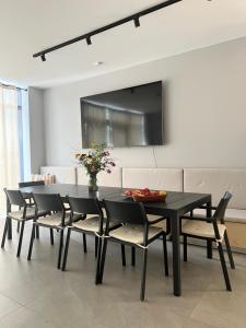 une salle à manger avec une table et des chaises noires dans l'établissement Pokoje nad jeziorem z opcją szkolenia żeglarskiego, à Pluski