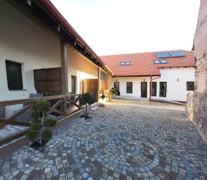 a courtyard of a building with a brick walkway at PENSIUNEA CASTELANA in Racoşu de Jos
