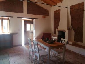 uma sala de jantar com uma mesa e cadeiras e uma lareira em Monte Alentejano ideal para relaxar na natureza em São Teotónio