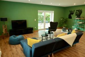 uma sala de estar com um sofá azul e uma televisão em Ferienhaus Bergauszeit in der alten Post em Nesselwang