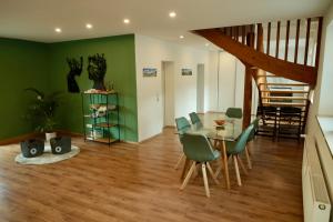 uma sala de jantar com paredes verdes e uma mesa e cadeiras em Ferienhaus Bergauszeit in der alten Post em Nesselwang