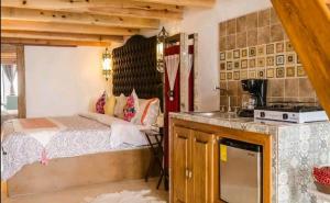 a bedroom with a bed and a kitchen with a stove at Villas del Sol in Bernal
