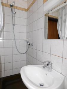 een witte badkamer met een wastafel en een douche bij Apartment Branko in Ptuj