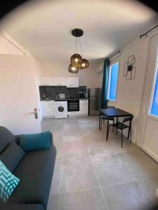 een woonkamer met een bank en een tafel bij Le Berlioz-Studio-Clim-Wifi-Balcon in Béziers