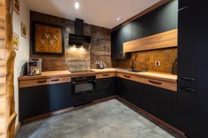 a kitchen with black cabinets and wooden counters at U Tadka dom z jacuzzi in Wisła