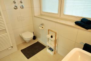 um banheiro com vaso sanitário e pia em Ferienhaus Bergauszeit in der alten Post em Nesselwang mais 15 fotografias