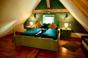 um quarto com uma cama verde num sótão em Ferienhaus Bergauszeit in der alten Post em Nesselwang