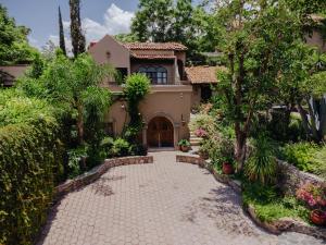 a house with a driveway and trees at Casa Liza in San Miguel de Allende
