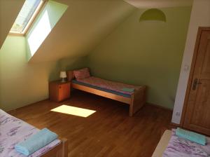 a attic room with a bed and a window at Domek Nad Dunajcem Liptak in Tylmanowa