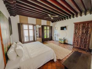 1 dormitorio con 1 cama blanca en una habitación en Casa Liza, en San Miguel de Allende