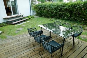 uma mesa e cadeiras sentadas num deque de madeira em Ferienhaus Bergauszeit in der alten Post em Nesselwang