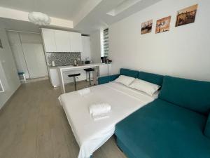 a living room with a blue couch and a kitchen at Fancy Studio with Sea View in Mamaia