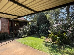 a patio with awning over a yard with plants at Howick Greendale 4 Self Catering Units Solar & Battery Back-Up in Howick