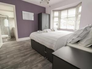 1 dormitorio con 1 cama grande y baño en Cwm Pennant, en Prestatyn