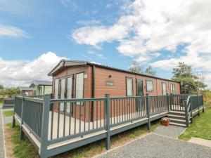 a tiny house with a green fence at 20 Wolds View in Ganton