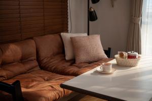 逗子市にあるCachtte Nagisa - Vacation STAY 95387vの茶色のソファ、リビングルーム(テーブル付)