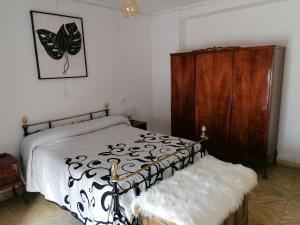 1 dormitorio con 1 cama y armario de madera en VILLA ROBLES, en Santisteban del Puerto