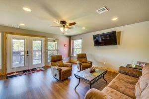 ein Wohnzimmer mit einem Sofa, Stühlen und einem TV in der Unterkunft Magical Pineville Oasis Gas Grill and Scenic Deck! 