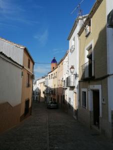 un callejón con edificios y un coche en una calle en VILLA ROBLES, en Santisteban del Puerto