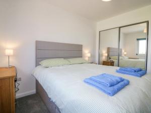 a bedroom with a large bed with blue towels on it at 1 Westenra Gardens in Peterhead