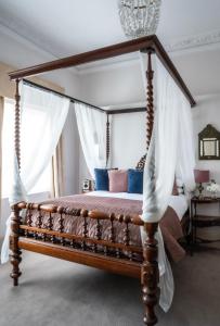 a canopy bed with a wooden frame in a bedroom at York & Albany in London