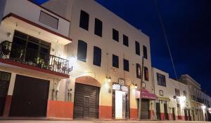 un grande edificio bianco su una strada di notte di Hotel Coroneo a Coroneo
