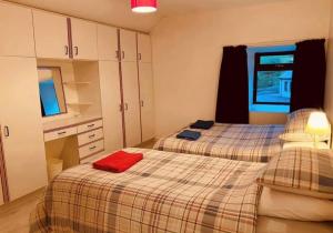 Dos camas en una habitación con una toalla roja. en Reelin bar holiday Accommodation en Cloghan