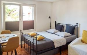 a bedroom with a bed and a table and a window at Cozy Home In Swinoujscie With Wifi in Świnoujście