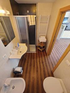 a bathroom with a toilet and a sink and a shower at Apartments Brunella in La Villa