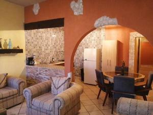 a living room with couches and a table and a kitchen at Villas del Sol in Bernal