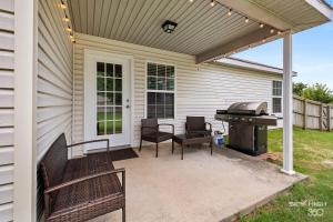 a screened in patio with a grill and chairs at The Trailhead-1 2 mi to Applegate Trail in Bentonville
