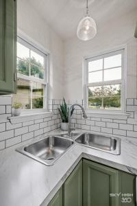 a kitchen with a sink and two windows at The Trailhead-1 2 mi to Applegate Trail in Bentonville