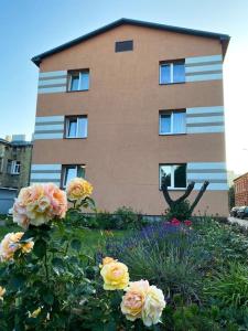 a building with a bunch of flowers in front of it at Piejūras laivinieks in Liepāja