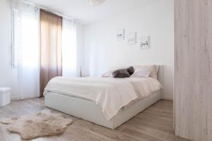 a white bedroom with a white bed and a mirror at Golden Location in Bagnolet