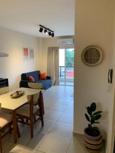 a living room with a table and a blue couch at Amaru - Departamento céntrico con cochera in Corrientes