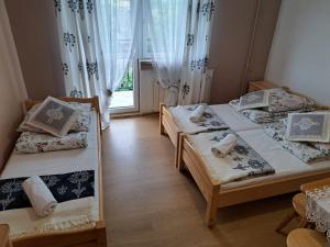 Un dormitorio con dos camas y una ventana. en Willa Grzesiczek, en Zakopane