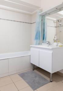 a white bathroom with a tub and a sink at Golden Location in Bagnolet