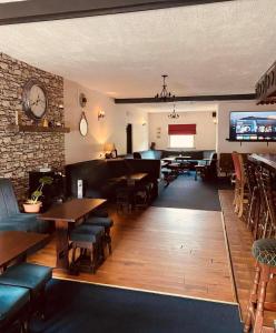 CloghanにあるReelin bar holiday Accommodationのテーブルと椅子、壁掛け時計のあるレストラン