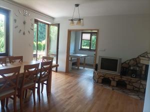 a living room with a table and a fireplace and a tv at Domek Nad Dunajcem Liptak in Tylmanowa